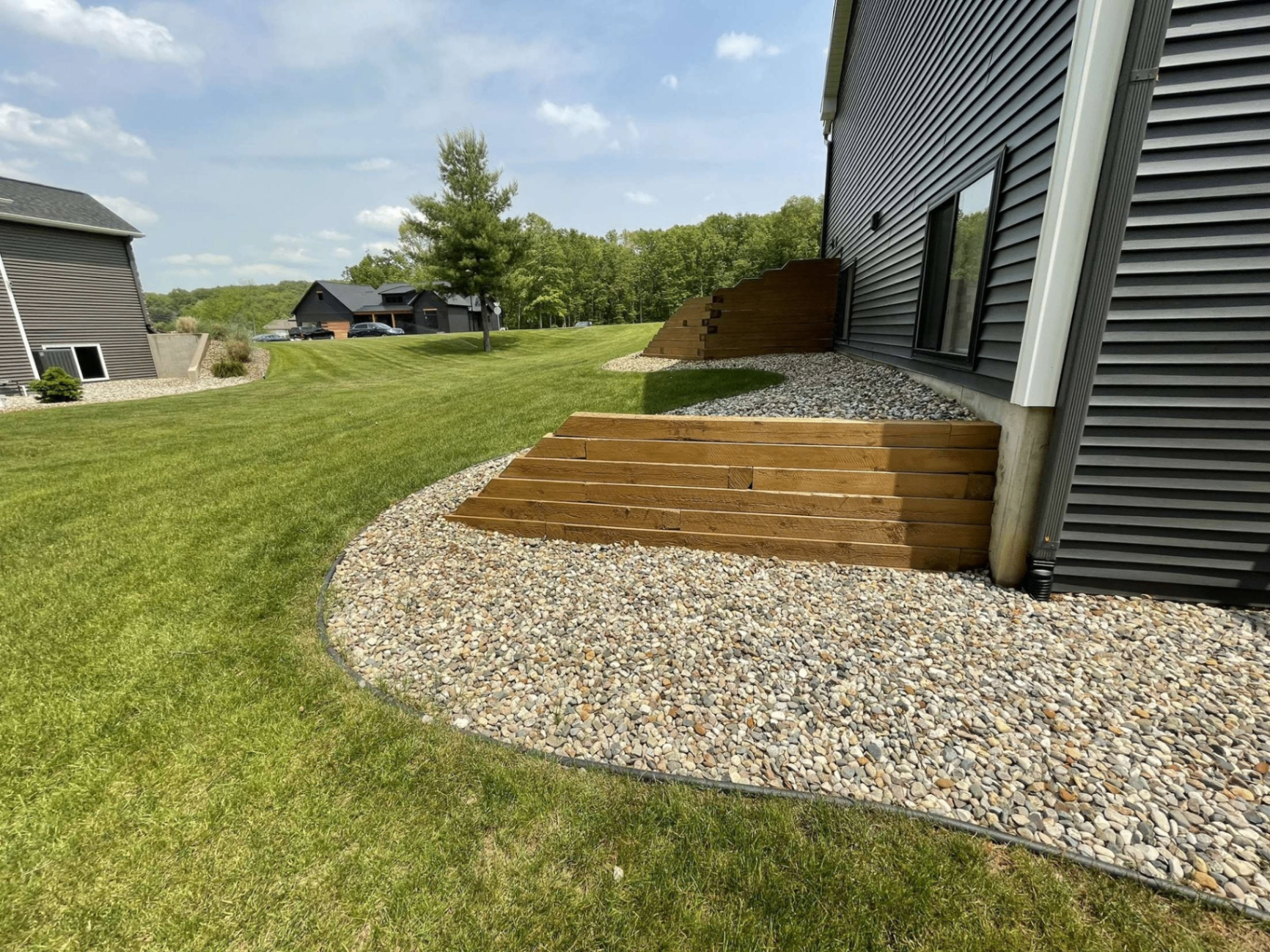 Wood retaining wall with river-rock drainage bed